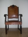 Fotografia de poltrona estofada, de confecção artesanal em madeira com assento e encosto em cour...